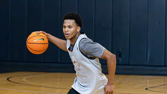 Gavin Hightower dribbles the basketball during practice 