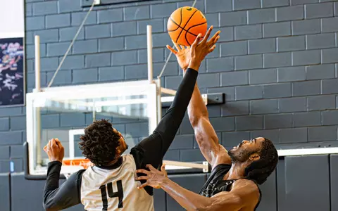 Samson Aletan and a teammate jump to battle for possession during practice on June 16.