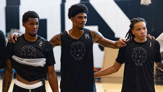 Devin Vanterpool Dink Pate and Malik Mack stand together in a team huddle during basketball practice