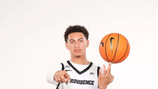 Men's Basketball player Miles Byrd posing during a photoshoot with a basketball
