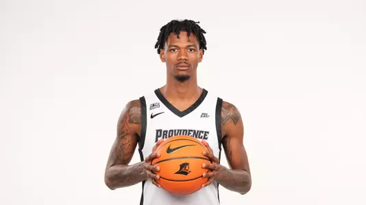Men's basketball player Dink Pate poses with a basketball in his hands during a photo shoot