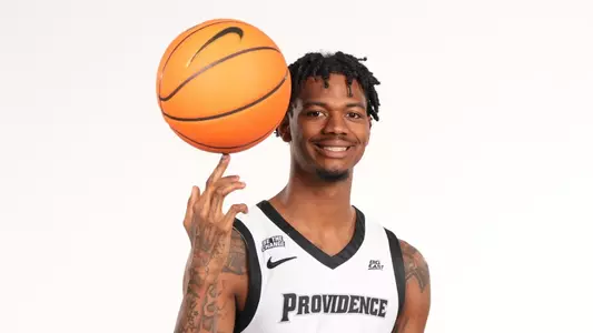 Men's basketball player Dink Pate poses spinning a basketball on his finger during a photo shoot