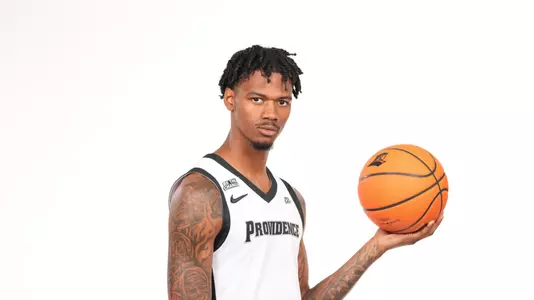 Men's basketball player Dink Pate poses with a basketball in his hand during a photo shoot
