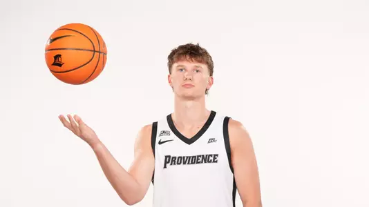 Men's basketball player Ryan Sabol poses throwing a ball into the air during a photo shoot