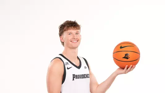 Men's basketball player Ryan Sabol poses with a basketball in his hand during a photo shoot