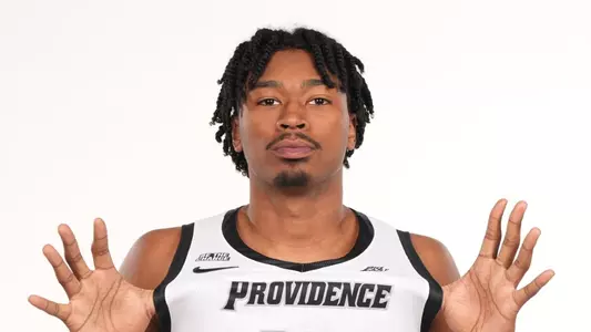 Men's basketball player Jacob Bannarbie flexing the Providence jersey in a photoshoot