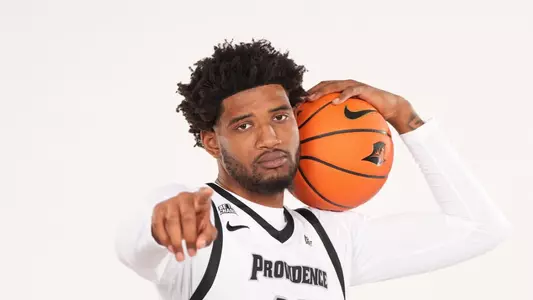 Men's basketball player Arrinten Page posing with a basketball during a photoshoot