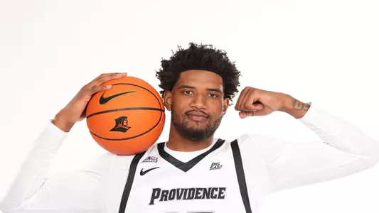 Men's basketball player Arrinten Page posing with a basketball for a photoshoot