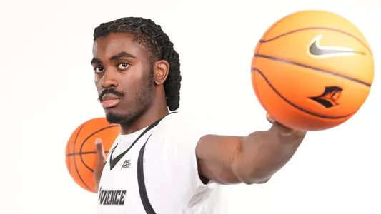 Men's basketball player Samson Aletan holding two basketball in his hands