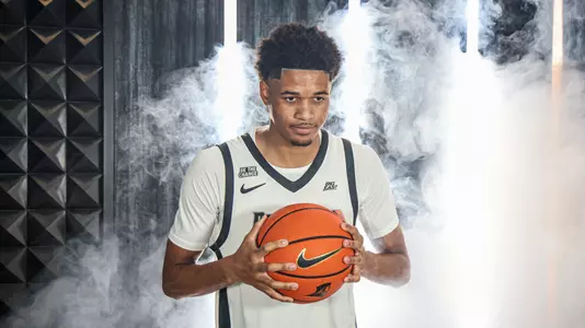 Men's basketball player Clyde Walters looking into the camera with smoke behind him