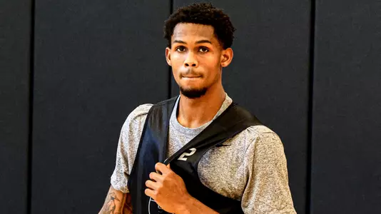 Men's Basketball player Devin Vanterpool holding a basketball on the sideline during practice 