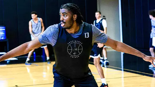 Men's basketball player Samson Aletan playing defense during practice