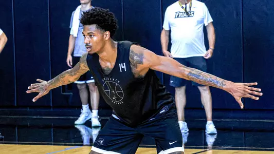 Mens Basketball Player Dink Pate playing defense during practice