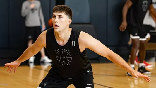 Men's basketball player Ryan Mela playing defense during a practice
