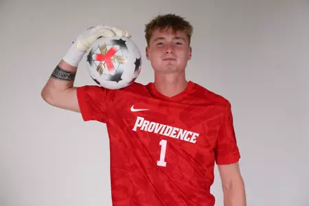 Ryan Carney holding ball on shoulder while facing the camera 