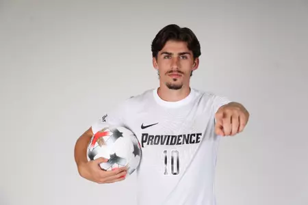 Alvaro Maneiro pointing at the camera while holding a ball 