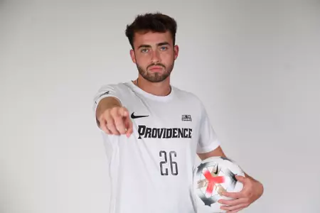 Brian Garrepy pointing at the camera with a ball on his hip 