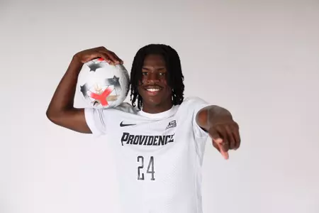 Mayowa Ajayi holding a ball on his shoulder and pointing at the camera 