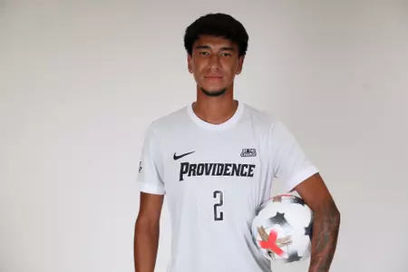 Steban Lopera holding ball on his hip facing camera 