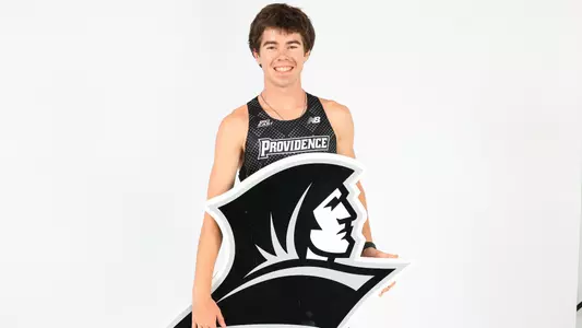 David Hayes holding up the Friars logo during a photo shoot 