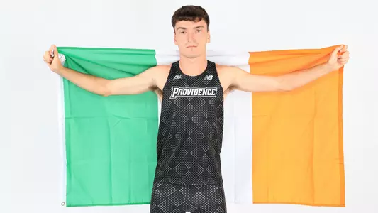 Cormac Dixon holding the flag of Ireland during a photo shoot