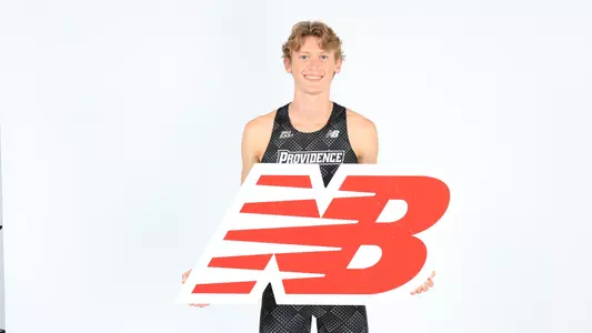 Jeb Hillary posing with the New Balance logo while at a photo shoot