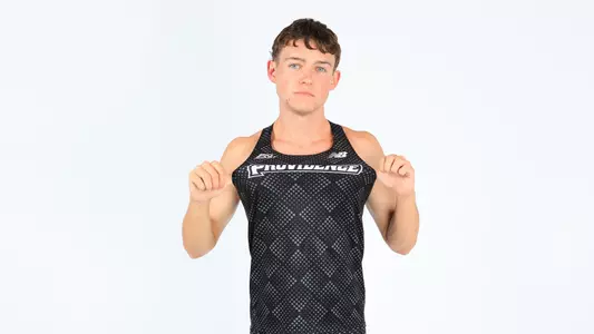 Jack Dowd pulling on his jersey showing the Providence logo during a photo shoot 