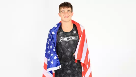 Dylan McCarthy posing with the American flag wrapped around his shoulders during a photo shoot 