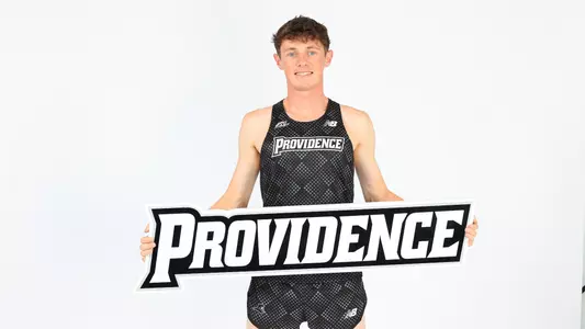 Jack Small holding up the Providence logo during a photo shoot 