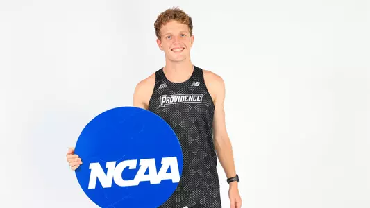 Ryan Welch holding the NCAA logo while at a photo shoot 