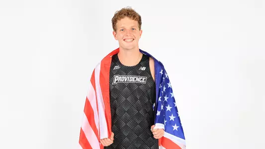 Ryan Welch posing with the American flag wrapped around his shoulders during a photo shoot 