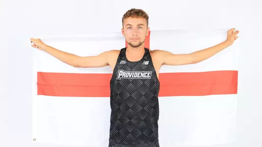 Sam Hodgson holding the flag of England during a photo shoot 