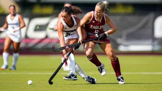 Darcy Quaile dribbles the ball with her stick while being defended by a player from Boston College.