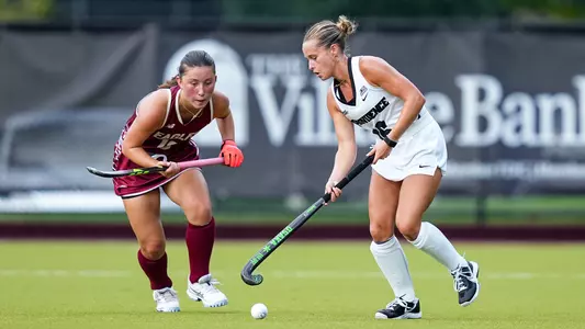 Piper Cline dribbles the ball with her stick while being defended by a player from Boston College.