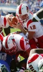 Louisville quarterback Brian Brohm dives over teammates Kurt Quarterman, bottom, and Eric Wood for the game's first touchdown against Kentucky.