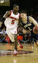 Notre Dame's Chris Quinn drives past Louisville's Taquan Dean during the first half of their basketball game Saturday, Feb. 4, 2006, in Louisville, Ky. (AP Photo/Ed Reinke)