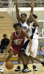 Louisville's Angel McCoughtry drives out of a double team by Georgetown's Kieraah Marlow and Jaleesa Butler, right, in the second half. (AP Photo/Kevin Wolf)
