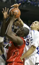 Juan Palacios tries to shoot between Kentucky defenders Patrick Patterson, left, and Derrick Jasper during the first half. (AP Photo/Ed Reinke)