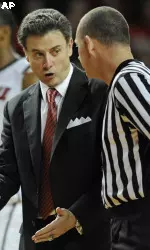 Louisville head coach Rick Pitino, center, discusses a call with referee Tim Clougherty.