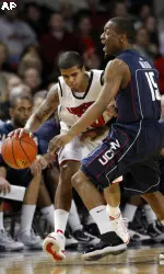 Edgar Sosa tries to drive past Connecticut's Kemba Walker during the first half.