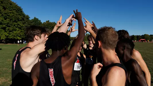 Men's cross country huddles before start of Live in Lou Classic