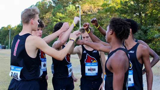 The men's cross country team breaks down the huddle before the start of the ACC Cross Country Championships.