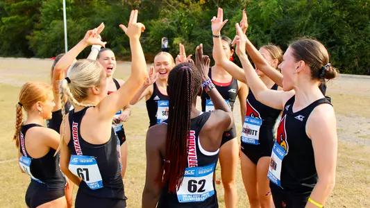 Women's cross country team huddles at the 2024 ACC Cross Country Championships