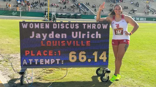 Jayden Ulrich poses with the scoreboard after moving fifth to NCAA history in the discus at the 2025 USF Alumni Invitational.