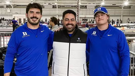 Christian Johnson and Aimar Palma Simo smile with coach Angelo Posillico after setting the school weight throw record
