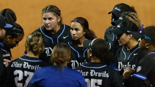 Members of the 2025 Duke softball team stand in a huddle in Gainesville, Fla.