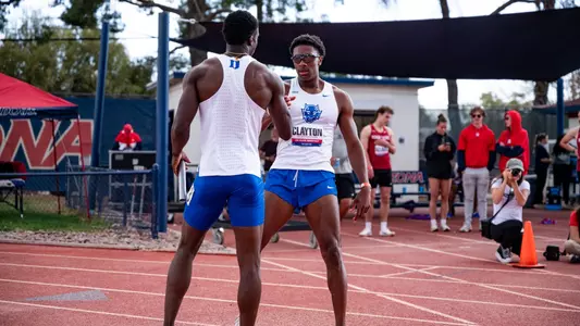 Joseph Taylor and TJ Clayton high five after winning 4x400m