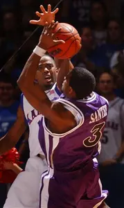 Corey Santee attempts a shot over Aaron Miles.