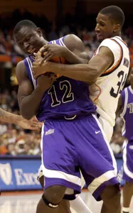 Femi Ibikunle battles for a rebound with Syracuse's Demetris Nichols during the first half. (AP Photo/Kevin Rivoli)