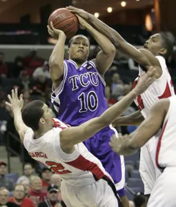 Marcus Shropshire shoots through the defense of Louisville's Francisco Garcia, left, and Larry O'Bannon, right. (AP Photo/Mark Humphrey)